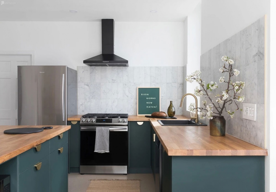 Phòng bếp nổi bật với gam màu xanh ngọc lục bảo đậm làm điểm nhấn. Bức tường backsplash ốp gạch thẻ dọc màu xám. Nội thất gọn gàng, tiện nghi và vững chãi.