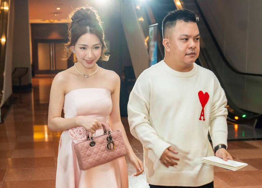 Hòa Minzy mặc váy cúp ngực phối túi xách hàng hiệu ton sur ton hồng đi ăn cưới cùng người quản lý.
