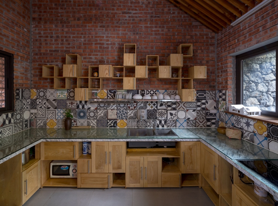 Hệ thống tủ bếp, kệ mở lưu trữ bằng gỗ kết hợp đá và mặt kính đa dạng, xen kẽ những khối hình học tạo nên sự sinh động. 