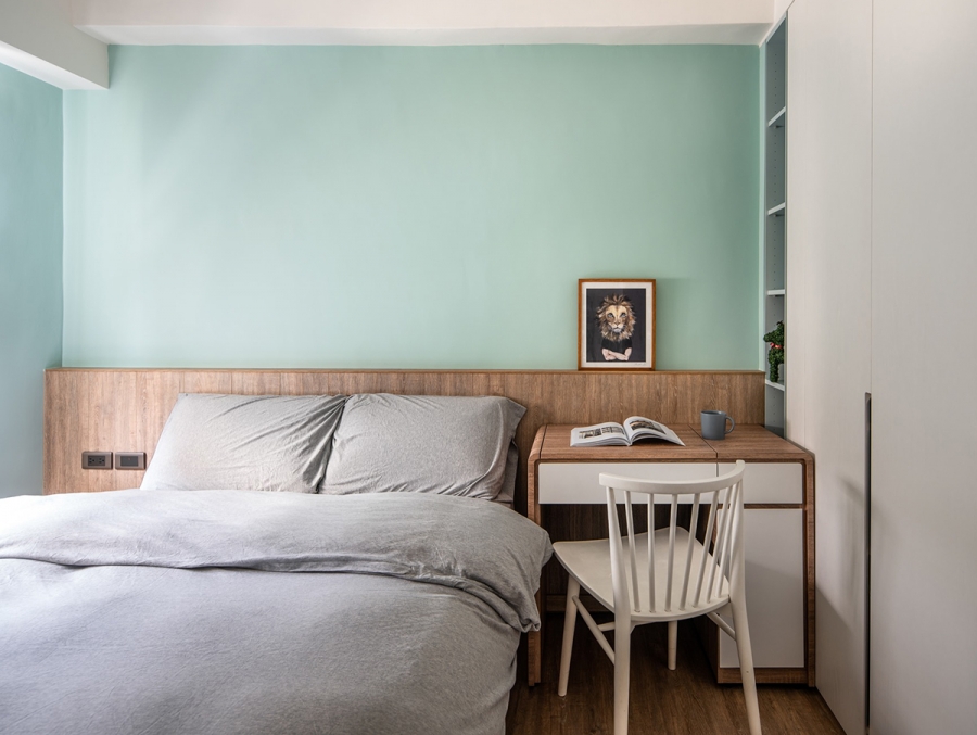 Một trong số hai phòng ngủ thiết kế nhẹ nhàng với gam màu xanh lam nhạt kết hợp bàn làm việc, đọc sách nhỏ gọn thay thế cho táp đầu giường. Tủ quần áo cao kịch trần cũng giúp căn phòng tiện nghi và gọn ghẽ hơn.