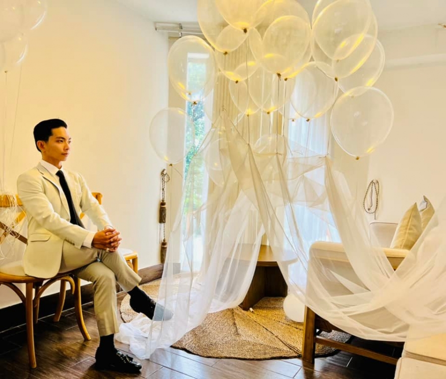 Bên cạnh anh là background vô cùng lãng mạn với nhiều bóng bay và khăn voan, khiến nhiều người liên tưởng ngay đến buổi chụp hình cưới ngọt ngào.
