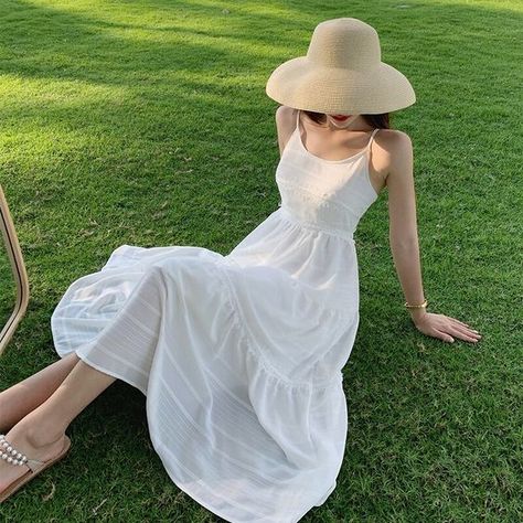 Một chiếc đầm trắng hai dây với điểm nhấn eo tôn dáng, bạn có thể dễ dàng kết hợp với những phụ kiện ngày hè như mũ cói, giày sandals.