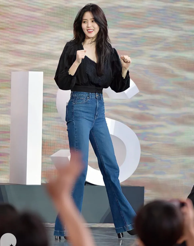 Diện áo blouse tay bồng, mang tông màu đen nhưng Han So Hee không bị cộng tuổi. Bí kíp của cô là kết hợp mẫu áo blouse tối màu với quần jeans xanh. Nhờ vậy, vẻ ngoài sẽ có sự trẻ trung, sành điệu mà không kém phần thanh lịch. Khi phối quần jeans ống suông, cạp cao với giày cao gót, đôi chân của người diện còn được kéo dài hơn.