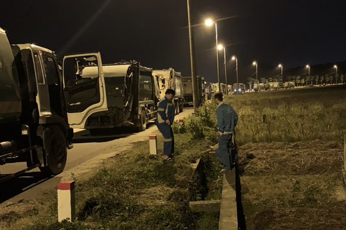 Xe rác xếp hàng dài trước cổng số 2 bãi rác Nam Sơn tối 23/10. Ảnh: Nguyễn Bình/VNE