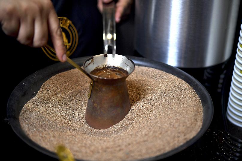 Cà phê Thổ Nhĩ Kỳ được pha bên trong một chiếc nồi đồng trên cát nóng trong một hội chợ Expo-Cafe ở Thành phố Mexico. Ảnh: Yuri Cortez / AFP