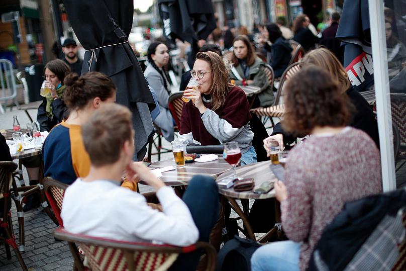 Mọi người uống bia trên sân thượng của một quán rượu ở Brussels. Ảnh: Francisco Seco/AP Photo