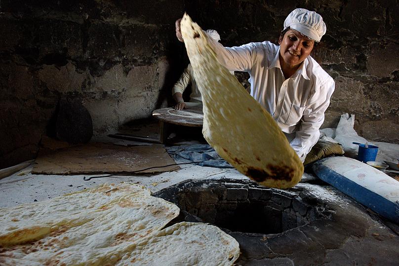 Một phụ nữ Armenia làm bánh mì dẹt không men truyền thống, trong một lễ hội xa hoa ở làng Pokr Vedi, phía nam Yerevan, gần núi Ararat. Ảnh: Karen Minasyan/AFP