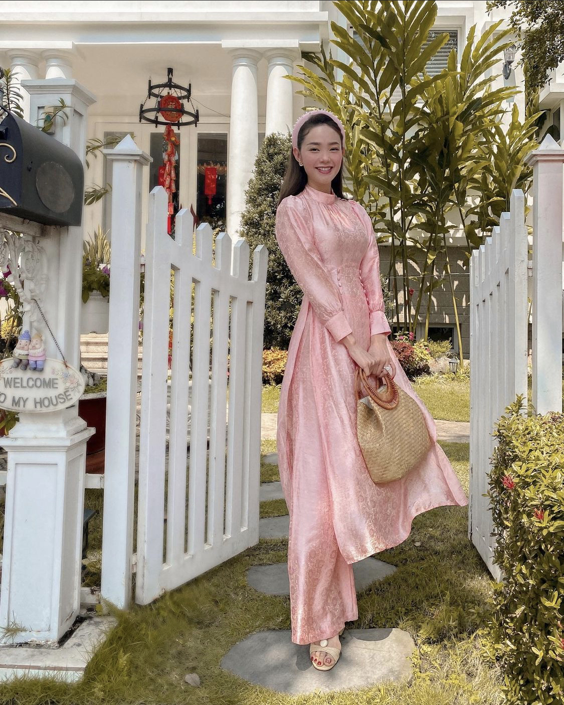 Dịp đầu năm, Minh Hằng lại lựa chọn diện nguyên một set áo dài màu hồng cực nữ tính. Cô nàng cũng khéo léo mix cùng túi cói và một đôi sandal màu be đơn giản cực dịu dàng.