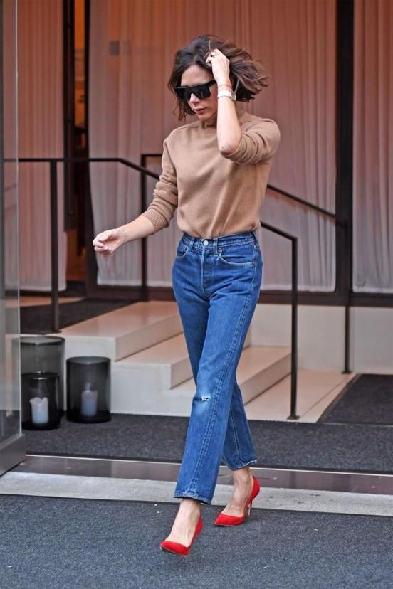 Khi không biết diện gì ra đường, bạn có thể tham khảo cách phối áo len cao cổ màu be với quần jeans của Victoria Beckham với điểm nhấn là một đôi giày cao gót màu đỏ.