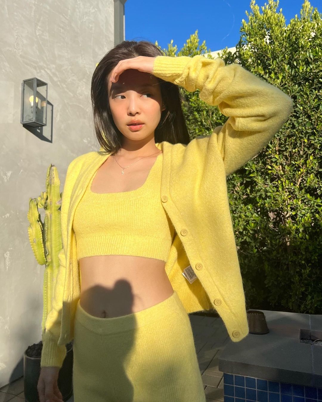 Trước Song Hye Kyo, nàng main rapper của BLACKPINK cũng từng diện một thiết kế tương tự với áo croptop, áo khoác và chân váy len màu vàng sáng. Kết hợp với phong cách trang điểm trong trẻo tự nhiên, nhan sắc của Jennie như tỏa sáng dưới ánh nắng mặt trời.