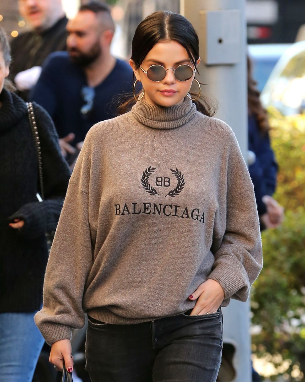 Bạn có thể thoải mái mix áo len trung tính với quần jeans mà không lo bị 'dừ'. Selena Gomez còn khéo tăng vẻ sang chảnh cho set đồ bằng cách kết hợp phụ kiện khuyên tai to bản và kính mắt tròn.