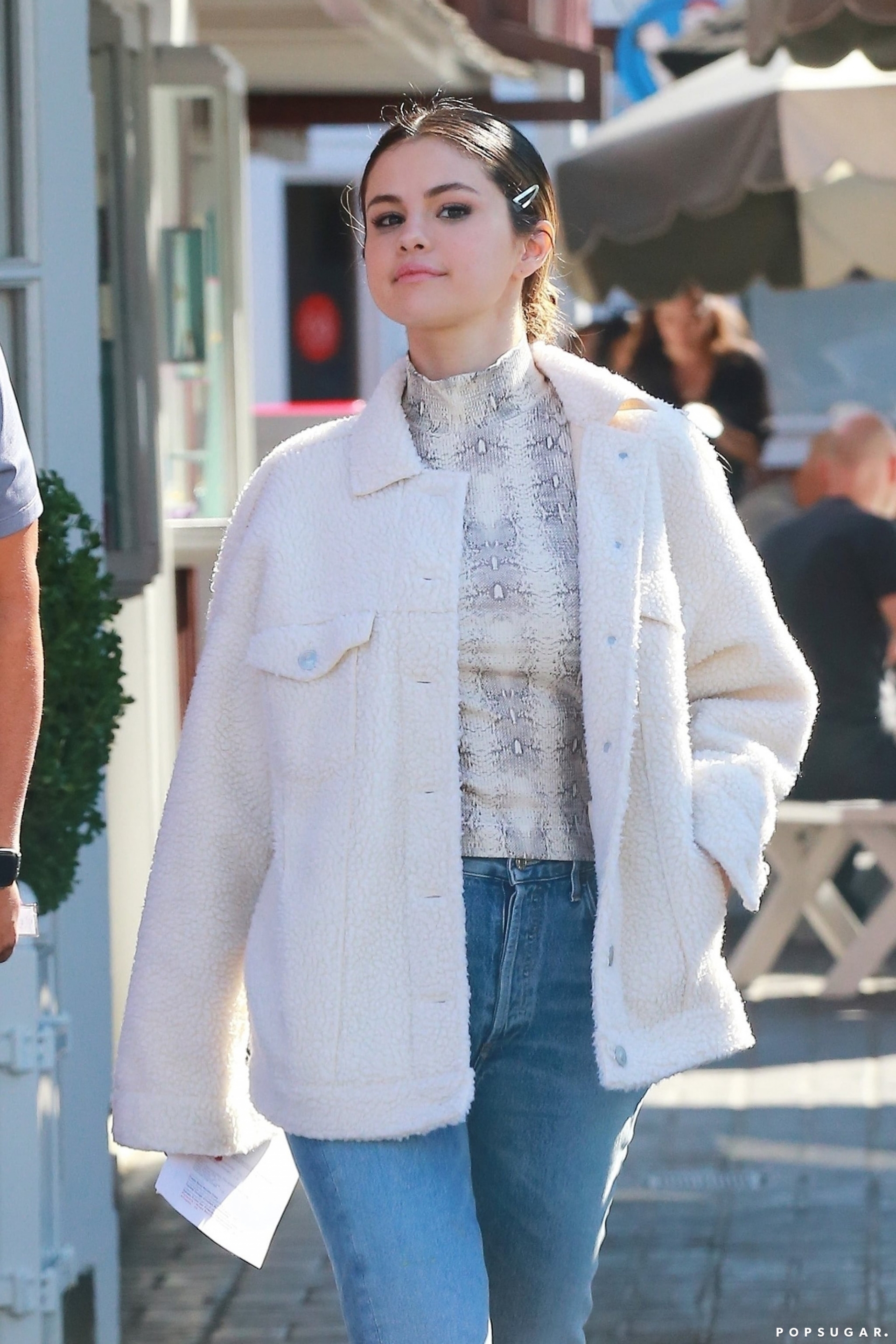 Với áo cao cổ họa tiết, bí kíp iện đẹp chính là kết hợp với những items trơn màu. Và outfit gồm áo cổ lọ họa tiết da rắn + áo bông trắng của Selena Gomez không chỉ đẹp mắt mà còn rất trẻ trung.