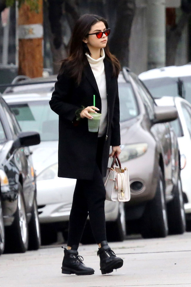 Tiếp tục là một outfit không quá cầu kỳ của Selena Gomez nhưng lại gây ấn tượng không nhỏ cho người mặc. Bạn chỉ cần mix áo len trắng cổ lọ + quần ống đứng + áo dạ dáng dài và boots thấp cổ là có ngay một set đồ ấm áp, trendy.
