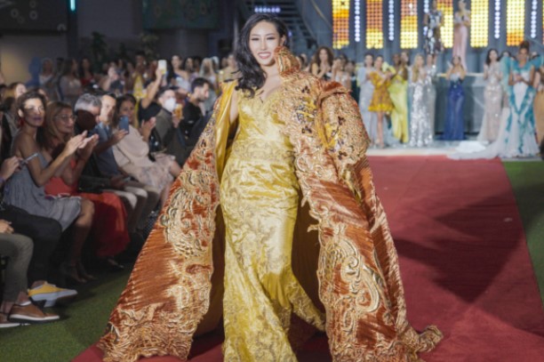 Ngoài ra, dù không lọt top 'siêu mẫu' nhưng Hoa hậu Hàn Quốc đã vượt mặt nhiều người đẹp để giành lấy danh hiệu 'Trang phục thiết kế đẹp nhất'. Người đẹp mặc một chiếc váy lụa màu vàng thêu kim sa vô cùng lộng lẫy đi kèm áo choàng được thiết kế tinh xảo không kém.