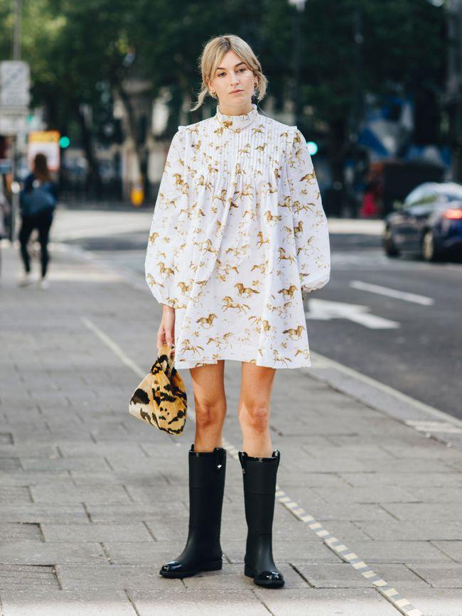 Camille Charriere, một blogger thời trang lại chọn cách mặc váy ngắn búp bê mix với boots đi mưa cao cổ màu đen khiến style xuống phố của cô vô cùng độc đáo và cá tính.