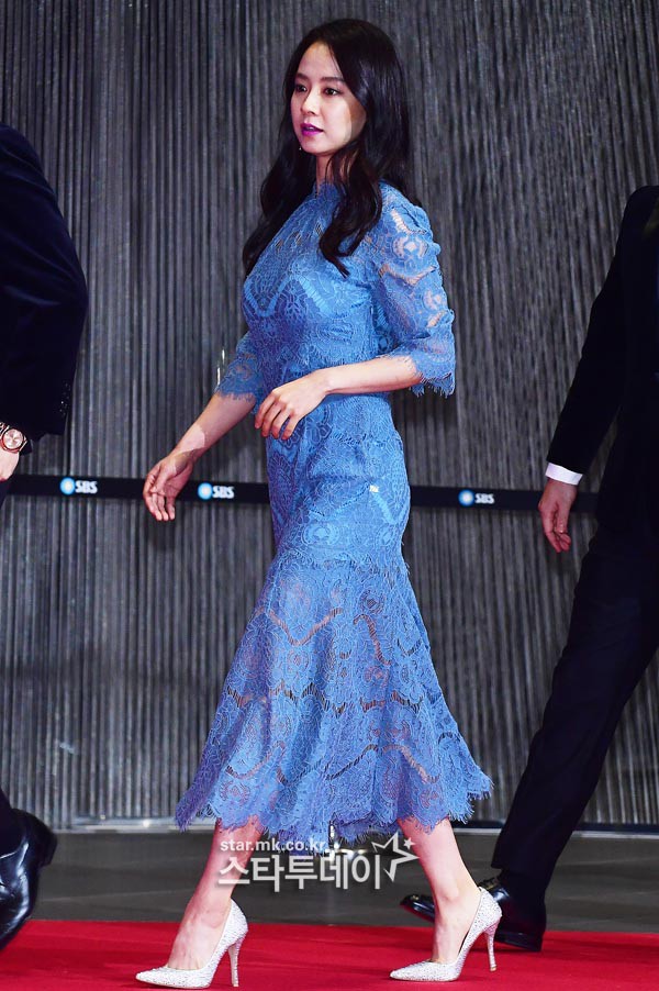 Dường như Song Ji Hyo rất yêu thích những chiếc váy ren nữ tính và thường xuyên chọn item này đồng hành lên thảm đỏ. Lần này nữ diễn viên vẫn chọn son tím và phối cùng đôi giày cao gót đơn giản màu trắng.