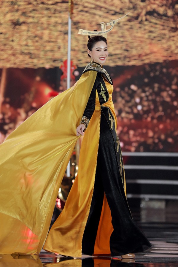 Trên sân khấu Hoa hậu Việt Nam, Đặng Thu Thảo cân đẹp chiếc áo dài màu đen vàng vương giả, đính kết cầu kì.