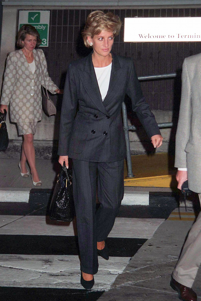 Diện bộ suit màu tối họa tiết kẻ sọc, để không bị dừ công nương Diana đã tinh tế phối cùng áo phông trắng basic. Cho đến hiện tại, đây là combo phối đồ được nhiều fashionisa áp dụng vì tính tiện dụng cũng như thời thượng xuyên thời gian của chúng. 