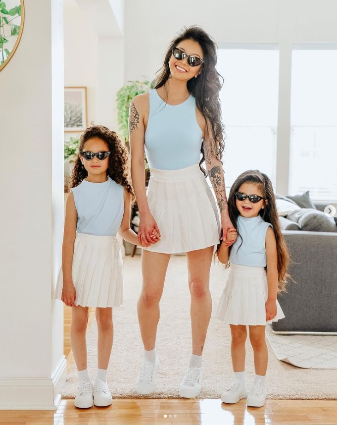 Vì mặc đồ chung với con gái nên Michelle thường lựa chọn những item kín đáo, trẻ trung một chút chẳng hạn như áo 3 lỗ cùng váy tenis trắng rồi đeo kính đen cho thật ngầu.