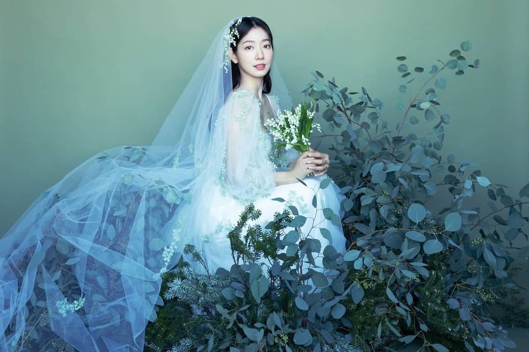 Park Shin Hye đẹp như nữ thần trong bộ ảnh cưới, cô mặc một chiếc váy cưới trắng voan dài lãng mạn, táo dáng giữa khung cảnh cây cối thơ mộng.