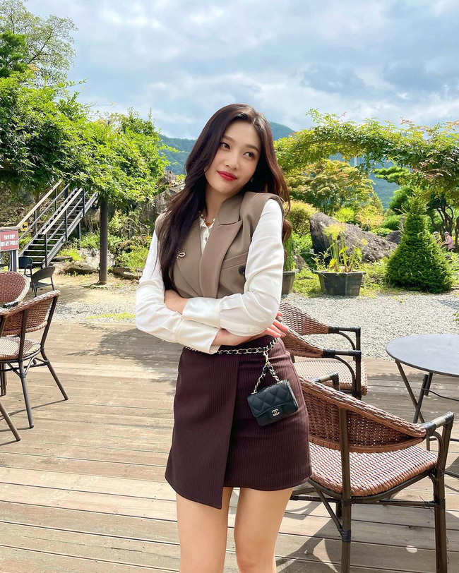 Joy có một outfit rất đáng để học hỏi để diện trong dịp Tết nguyên Đán sắp tới. Cô nàng thoải mái mix chân váy màu nâu đỏ cùng áo sơ mi trắng kết hợp gilet màu be. Để thêm phần tiểu thư, nữ idol còn dùng một chiếc túi Chanel mini làm thắt lưng.