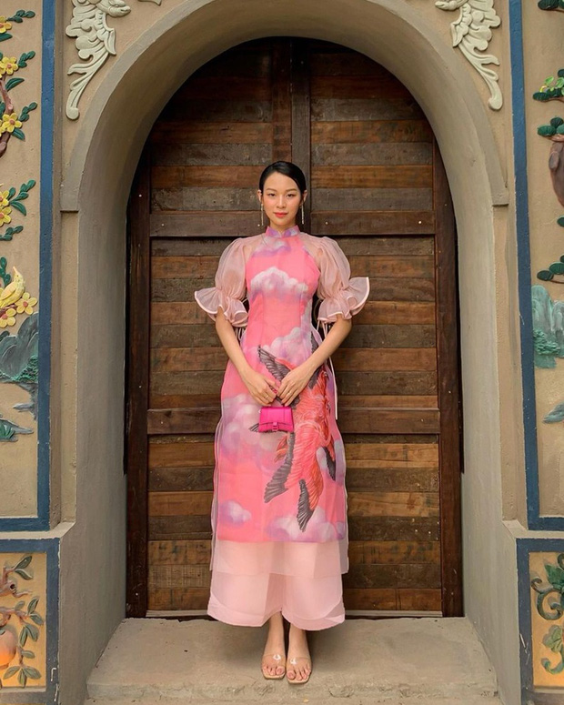 Phí Phương Anh cũng lựa chọn chiếc áo dài họa tiết mây hạc bằng voan nhiều lớp vô cùng nữ tính. Để tránh rối rắm, cô nàng đeo túi Hourglass phiên bản mini của Balenciaga màu hồng cùng ton có giá gần 21 triệu đồng.