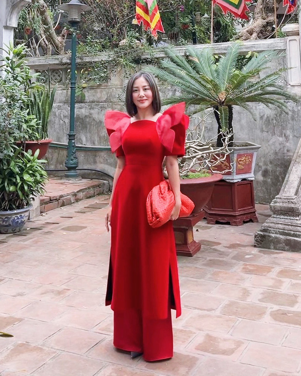 Văn Mai Hương cũng gia nhập hội mặc váy đỏ dịp Tết nhưng thay vì thiết kế thông thường, chiếc áo dài của nữ ca sĩ có thiết kế vai áo cách điệu hết sức ấn tượng. Để ton sur ton với trang phục, nữ ca sĩ chọn mẫu túi màu đỏ Pouch in Intrecciato Nappa của Bottega Veneta có giá 68 triệu đồng.