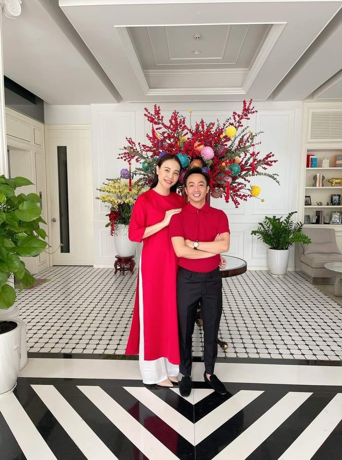 Cả Đàm Thu Trang và chồng đều lựa chọn sắc đỏ trong dịp Tết nhưng nếu ông xã Cường Đô la mặc áo polo đỏ ngắn tay thì Đàm Thu Trang lại nền nã trong chiếc áo dài truyền thống.