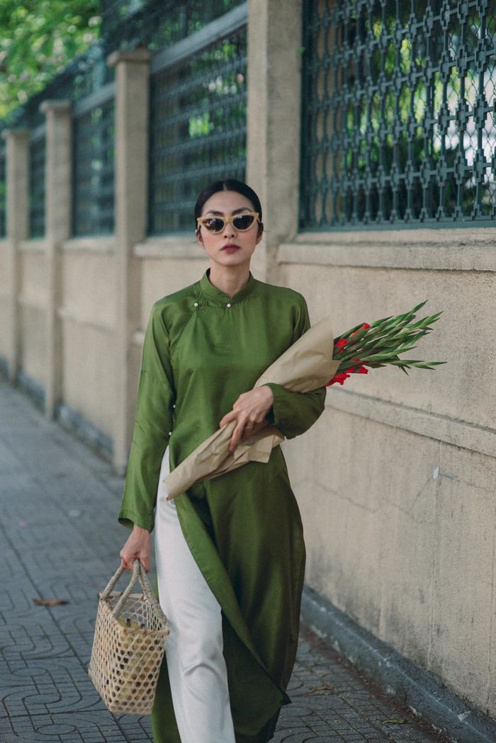 Vẫn bộ ảnh này vào năm ngoái, người đẹp từng gây ấn tượng khi lựa chọn áo dài màu xanh và thay vì túi hiệu, Hà Tăng chọn làn tre - một phụ kiện không thể thiếu của các bà, các mẹ khi đi chợ.