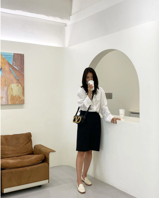 Thi thoảng nữ diễn viên sẽ hoá thân thành 'nhân viên công sở' với áo sơ mi trắng và chân váy lửng. Chiếc túi của thương hiệu Valentino thành công trong việc giúp Park Shin Hye nâng tầm phong cách.