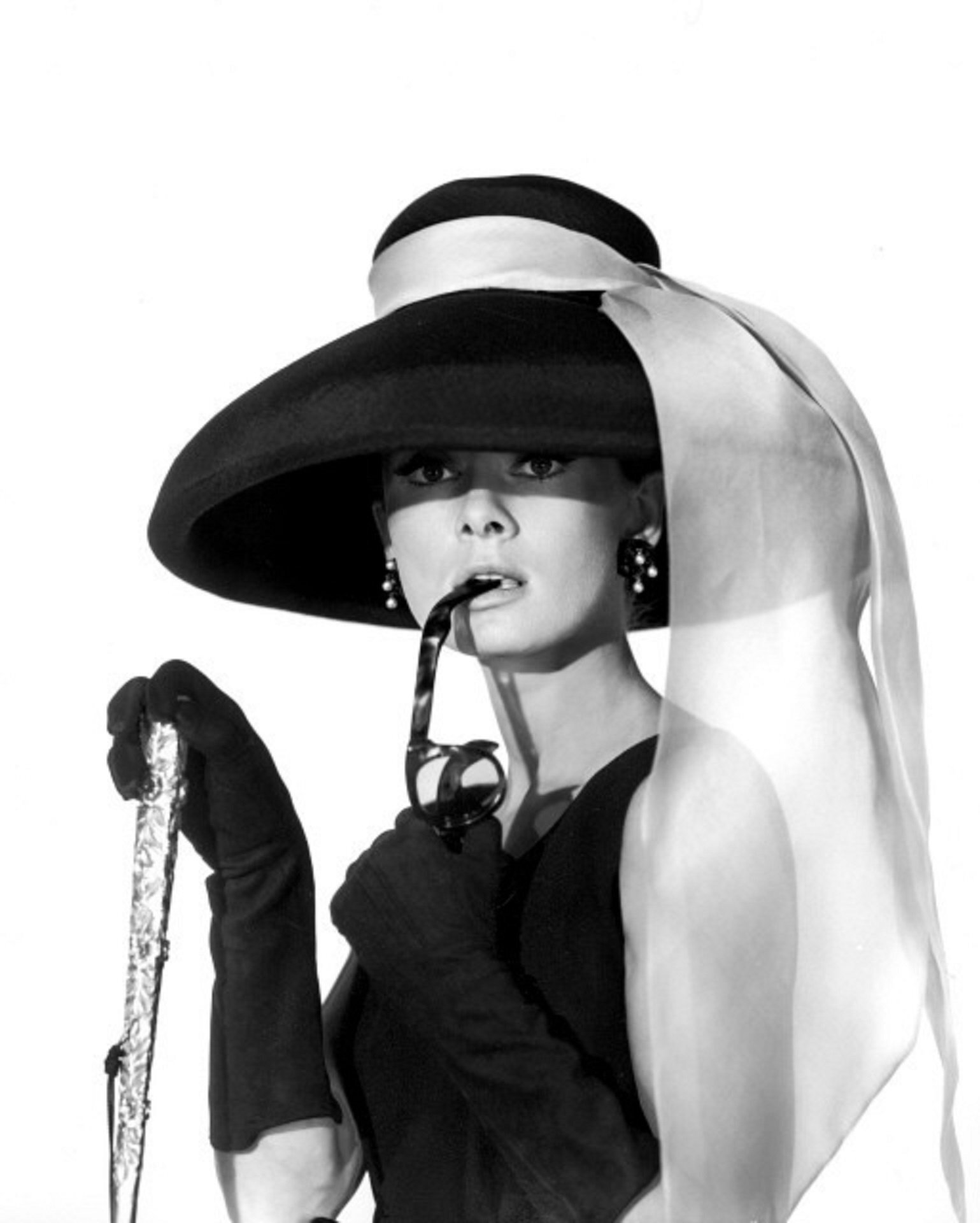 Khoảnh khắc huyền thoại của Audrey Hepburn với chiếc mũ rộng vành và khoăn voan lụa thắt nơ hờ hững.