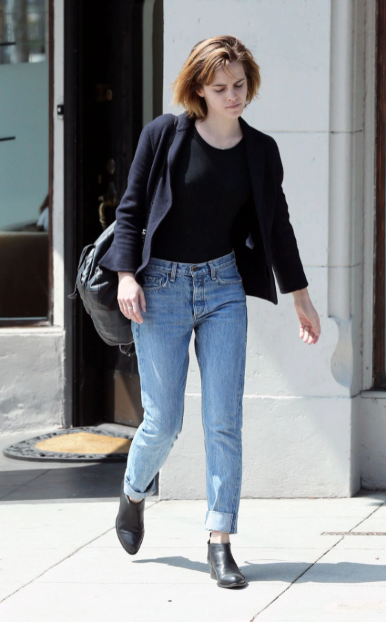 Áo thun đi với quần jeans xanh là cách phối đồ được nhiều sao nữ Hollywood yêu thích và Emma Waston cũng không ngoại lệ. Cô nàng thoải mái khoác thêm áo trong thời tiết se lạnh và đeo vai một chiếc túi da lớn.
