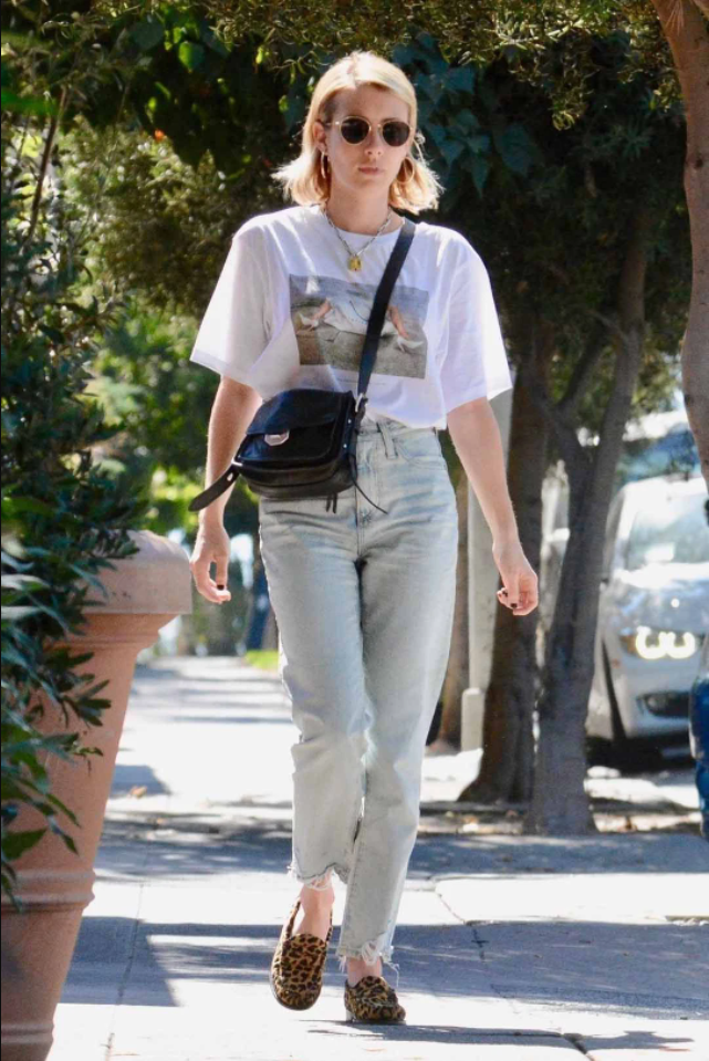 Quần jeans + áo phông trắng in hình + giày hoạ tiết da báo đơn giản nhưng đẹp không tưởng khi Emma Robert kết hợp với phụ kiện là túi đeo chéo và kính mắt đen thời thượng.