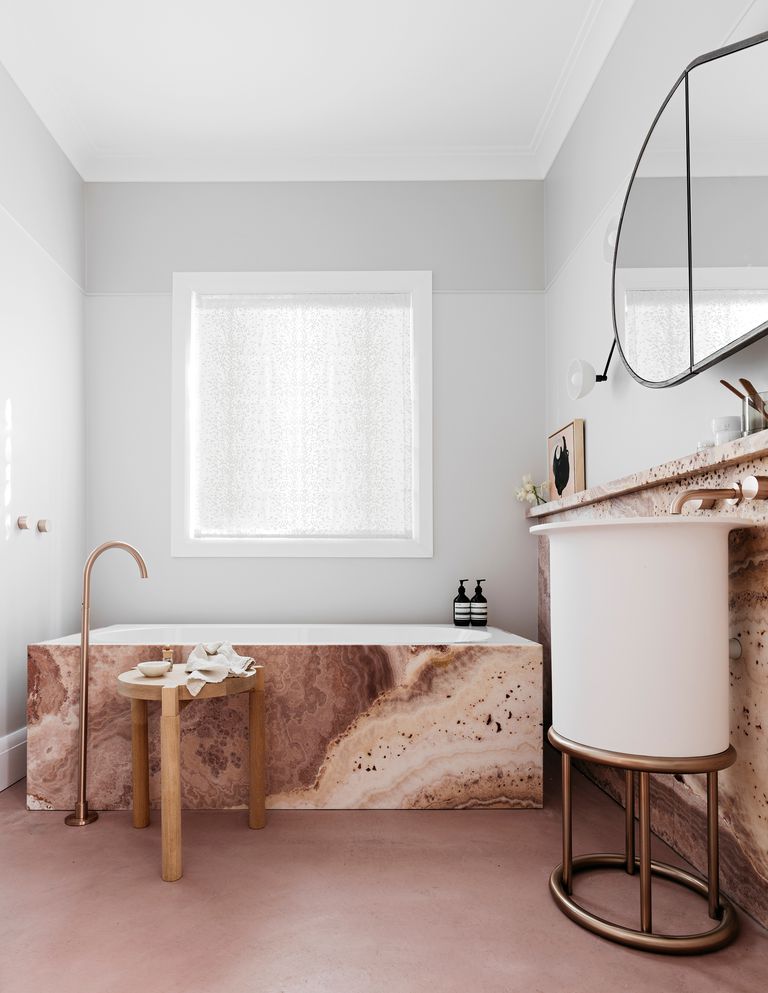 Dự án do Decus Interiors Studio thiết kế với không gian phòng tắm đẹp một cách yên bình, tĩnh lặng. Một phần nhờ gam màu trắng tinh khôi của bức tường đối lập với sơn sàn màu be đậm, một phần nhờ đá ốp bồn tắm và bồn rửa màu nâu ấm áp.