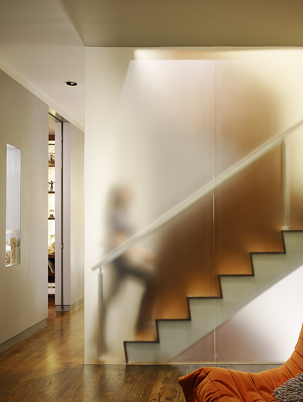 Bức tường bằng vật liệu polycarbonate đóng vai trò như lan can cho cầu thang tạo cảm giác huyền ảo.
