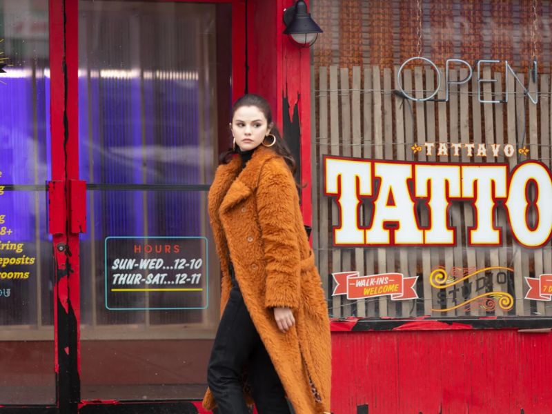 Selena Gomez với vai Mabel trong Only Murders in the Building, mặc một chiếc áo khoác màu nâu teddy