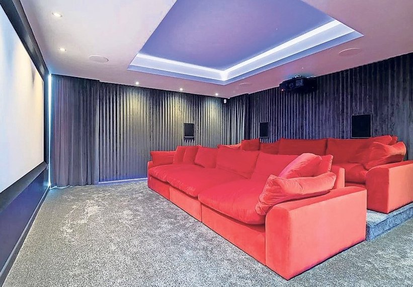 Biệt thự có phòng xem phim với ghế sofa đỏ cỡ lớn tiện thư giãn.