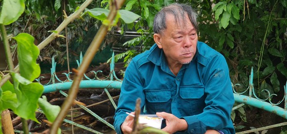 Cụ Nguyễn Văn Lài bật khóc khi nhận suất cơm nóng sau 5 ngày nhịn đói giữa mênh mông nước lũ. Ảnh: Sài Gòn giải phóng.