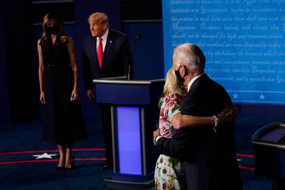 Hai vợ chồng đương kim Tổng thống Donald Trump trang nghiêm nhìn vợ chồng ứng viên Đảng Dân chủ Joe Biden ôm hôn thắm thiết.