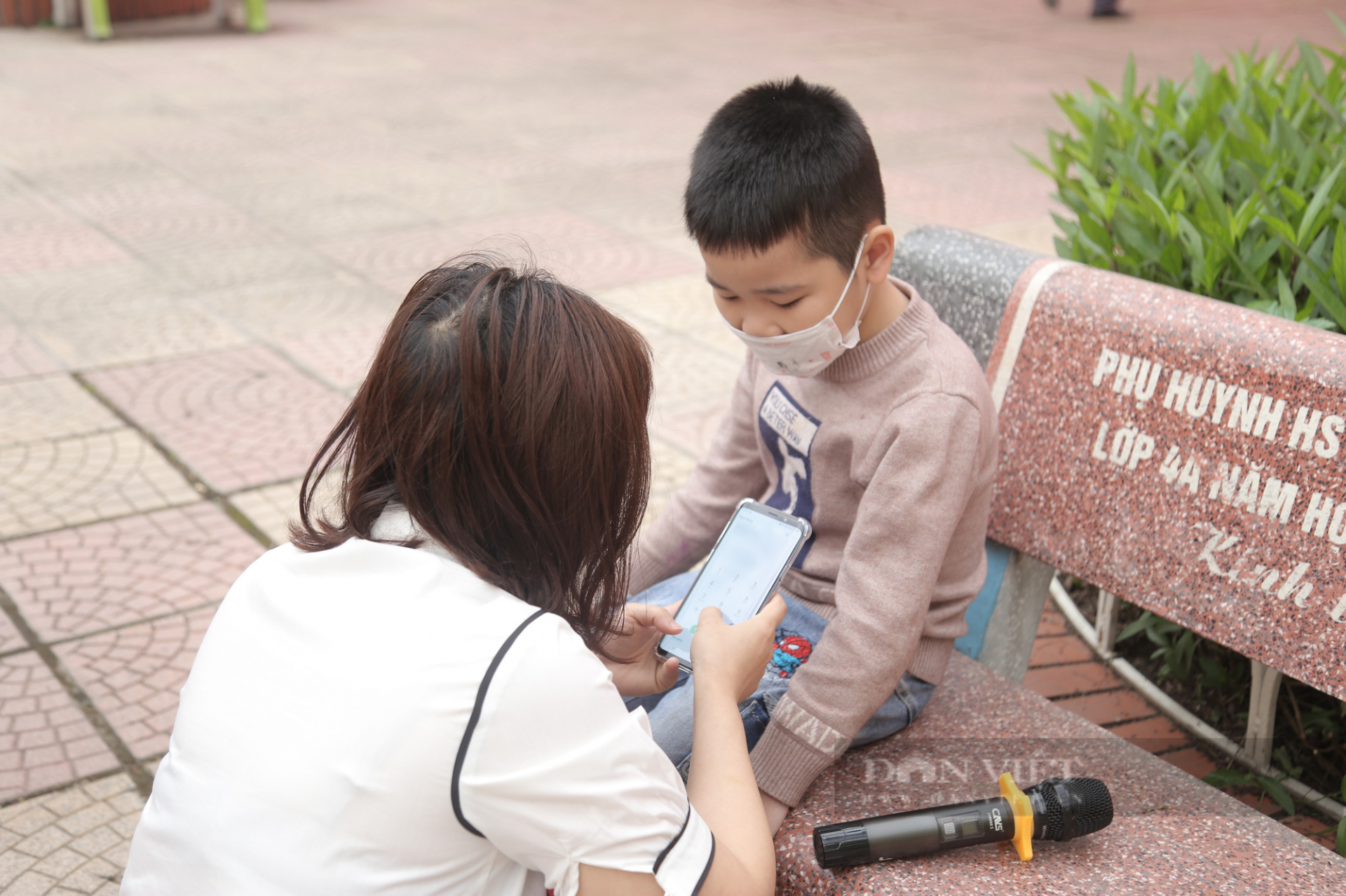 Cậu bé bị bố đưa đến nhầm trường đang ngồi đợi bố đến đưa đi học (Ảnh: Dân Việt).