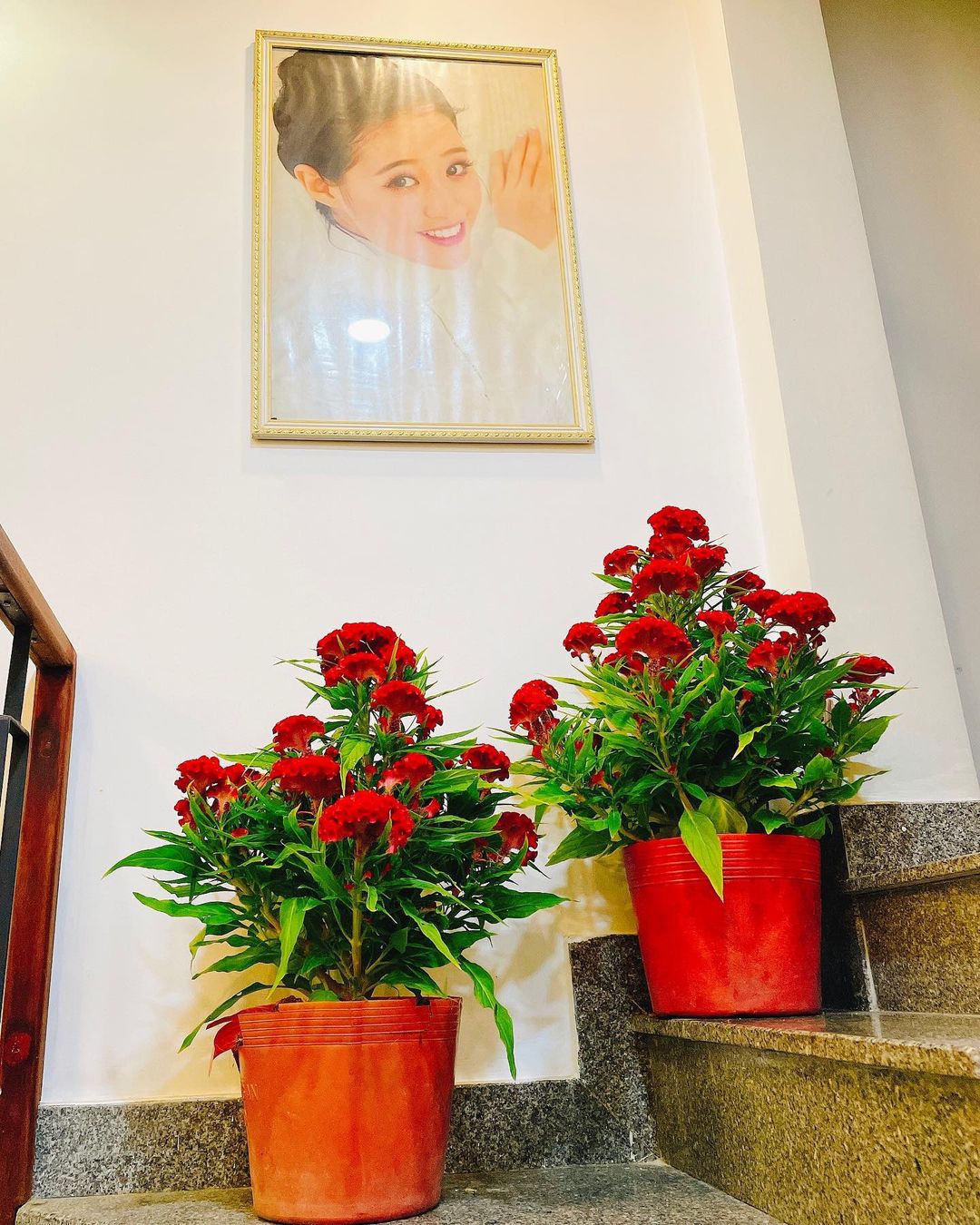 Cầu thang lên lầu được trang trí bằng hoa tươi và ảnh của Khánh Vân.