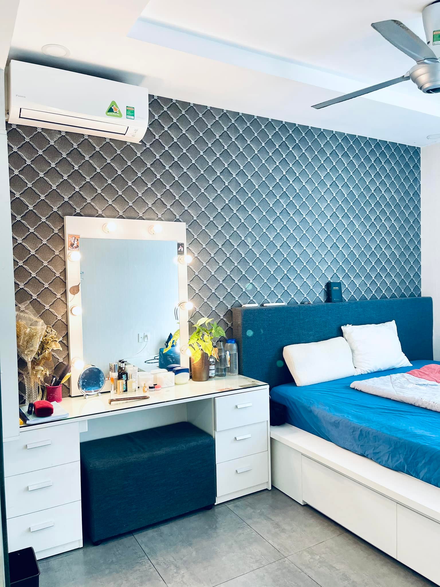 Phòng ngủ chính trong căn hộ dễ chịu với màu xanh - trắng.