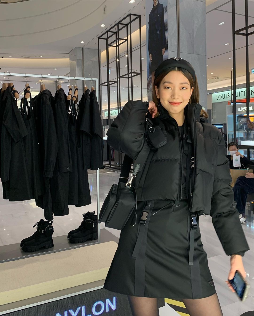 Lee Ho Jung trông cá tính khi sử dụng áo phao crop top màu đen hoàn thiện bộ outfit váy áo cùng màu của mình.