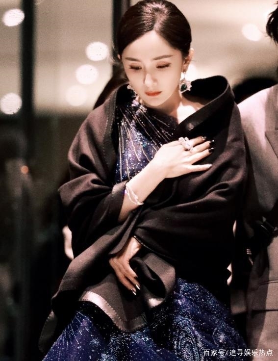 Dương Mịch dúng khăn choàng lụa đen để giữ ấm và làm phụ kiện thanh lịch đi cùng bộ váy khi tham dự sự kiện.