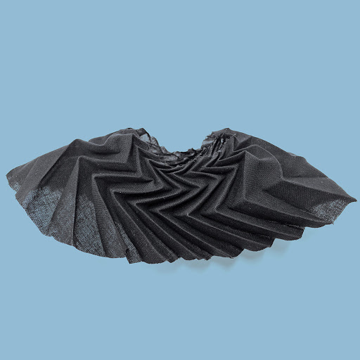 Nhà thiết kế Ryan Yario Masin đã sáng tạo ra chất liệu độc đáo này bằng cách kết hợp giữa nghệ thuật xếp giấy Origami và chất liệu Axetic có khả năng cố định và định hình ngay cả khi bị kéo giãn, không hồi lại kích thước ban đầu.