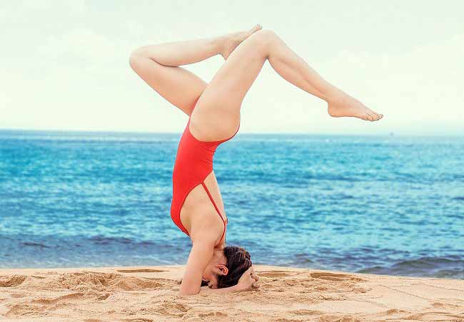 Phương Trinh Jolie còn đầu tư background cực xịn khi thả dáng yoga chồng chuối trên biển đầy quyến rũ. Phương Trinh chia sẻ mình tập yoga 3 buổi/tuần kết hợp với tập gym để duy trì vóc dáng xinh đẹp.