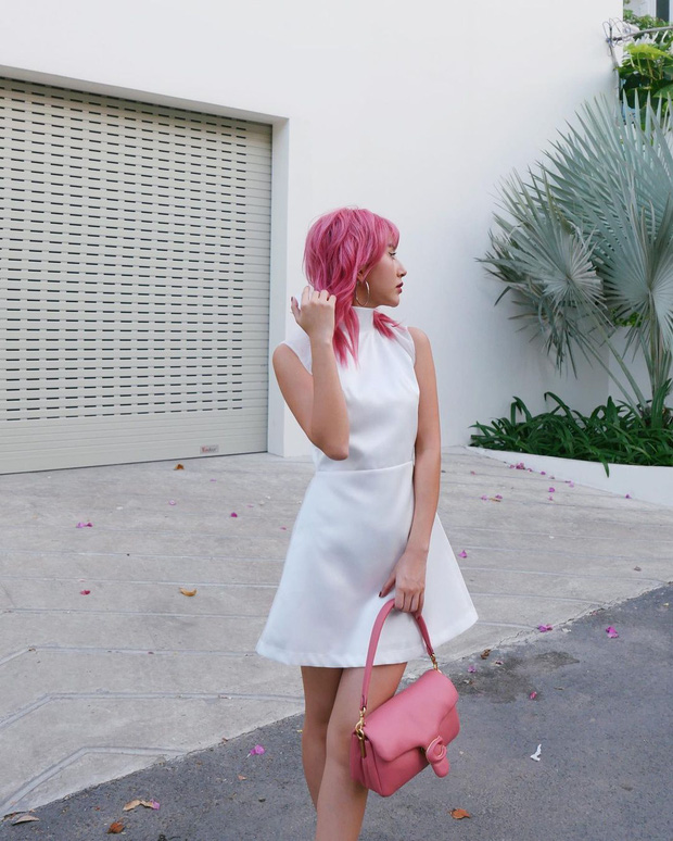 Fashionista sinh năm 1997 nhẹ nhàng mặc một chiếc đầm trắng để làm nổi bật màu tóc và chiếc túi hiệu màu hồng cá tính.