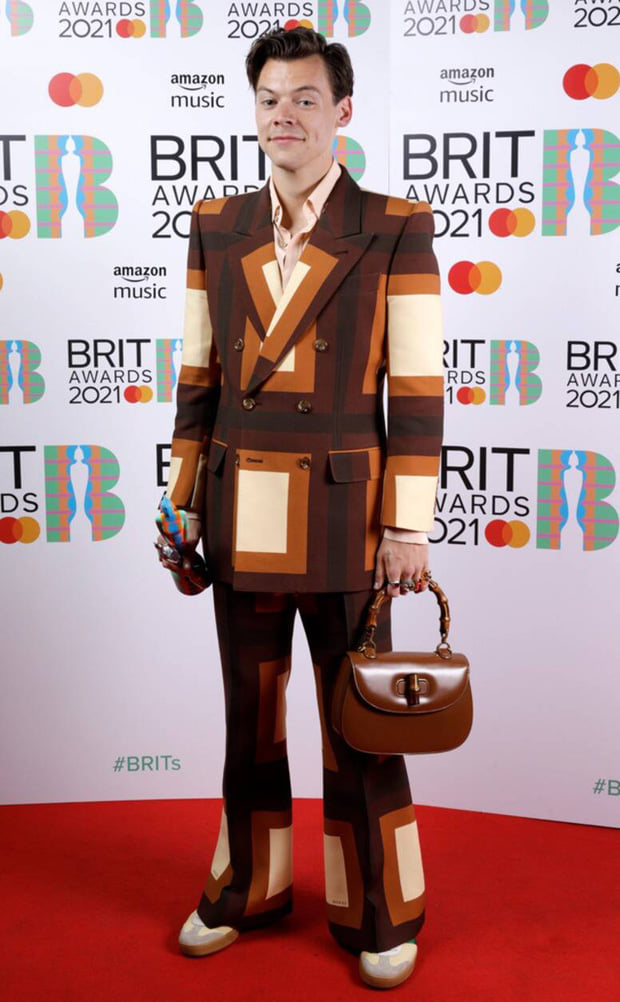 Harry Style chải chuốt gọn gàng, lên suit phong cách disco hoạ tiết ô vuông và mang túi Gucci quai gỗ trên thảm đỏ.