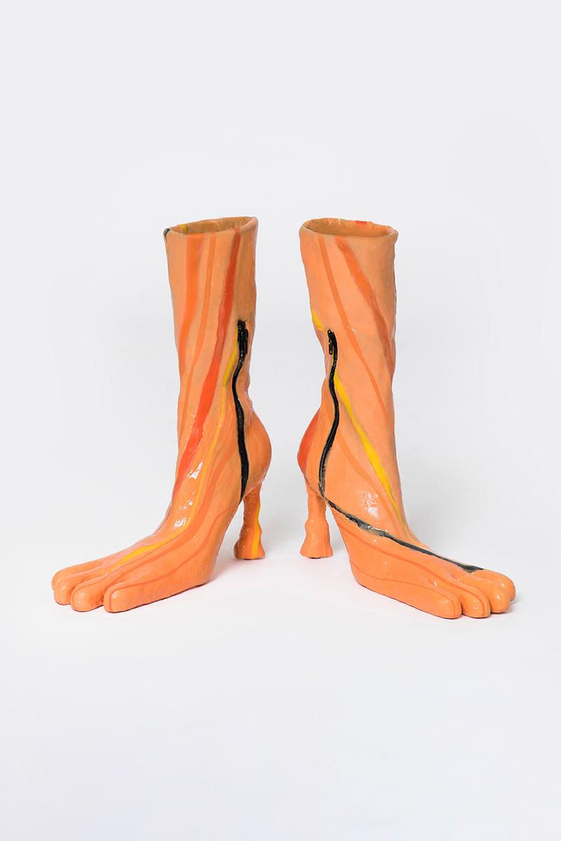 Mẫu ankle boots với chất liệu da bóng cao cấp, đế vuông chắc chắn nhưng phần mũi giày lại được tạo hình như đôi bàn chân.