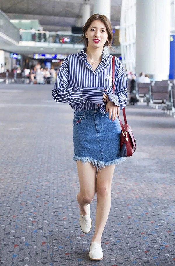 Bae Suzy khoe được lợi thế đôi chân thon dài, vóc dáng cũng trông thanh thoát hơn với chân váy jeans và áo sơ mi sọc xanh. Chiếc túi và màu son cùng tông màu giúp diện mạo 'Tình đầu quốc dân' thêm phần thanh lịch.